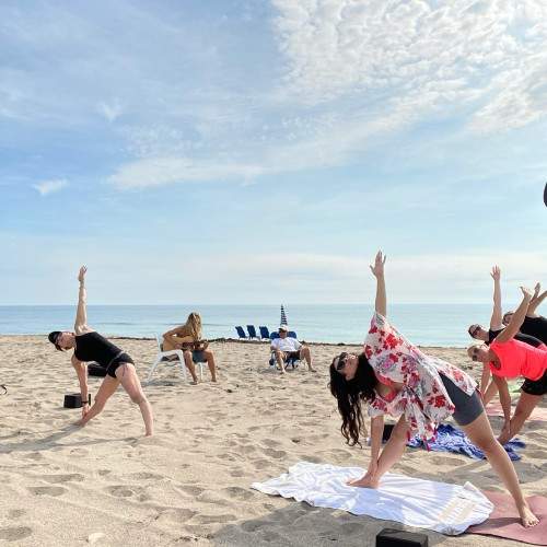 Group doing yoga on the beach