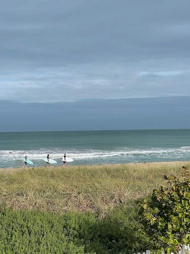 three people boogy boarding on the beach